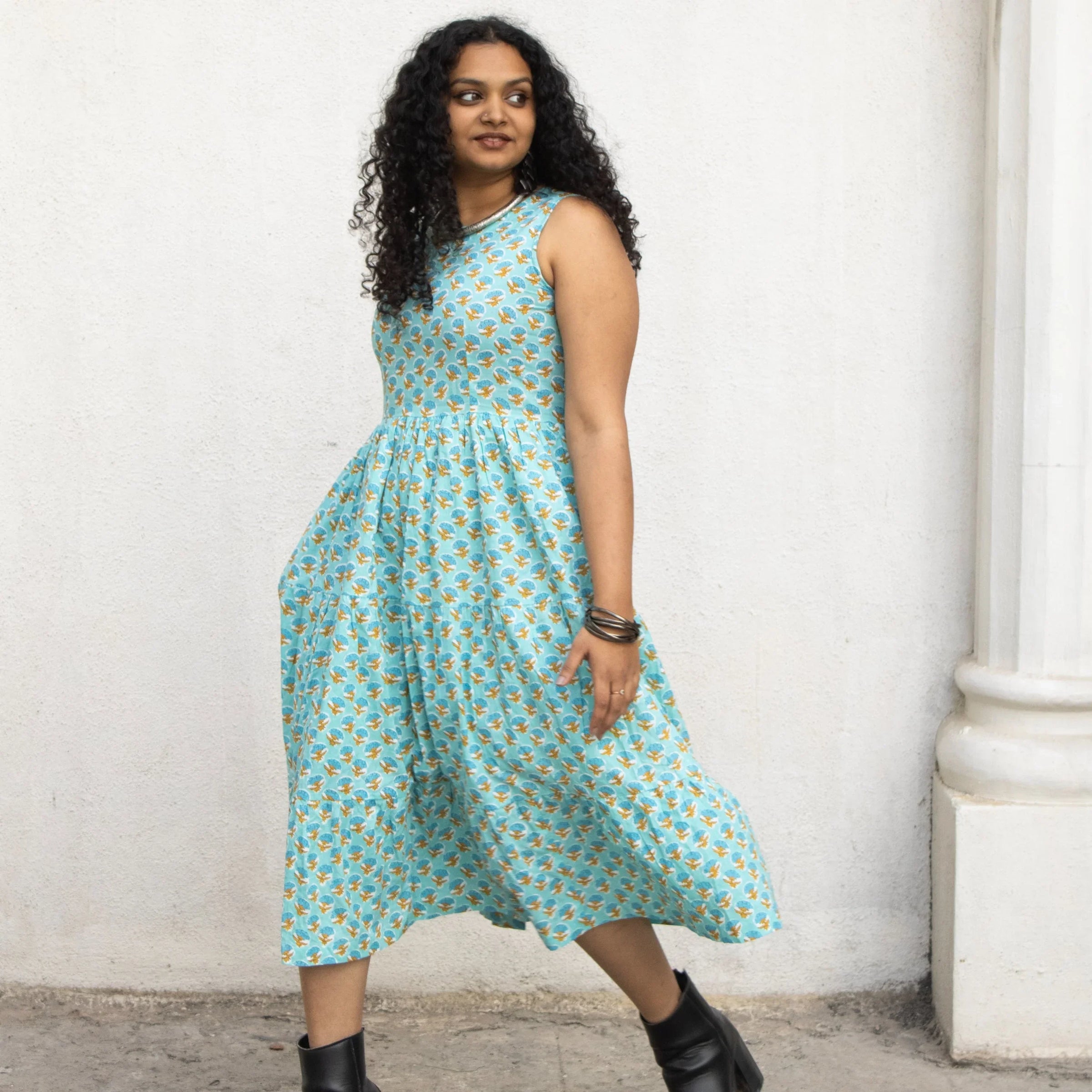 Sleeveless light blue midi dress with gathered waist and flared skirt.
