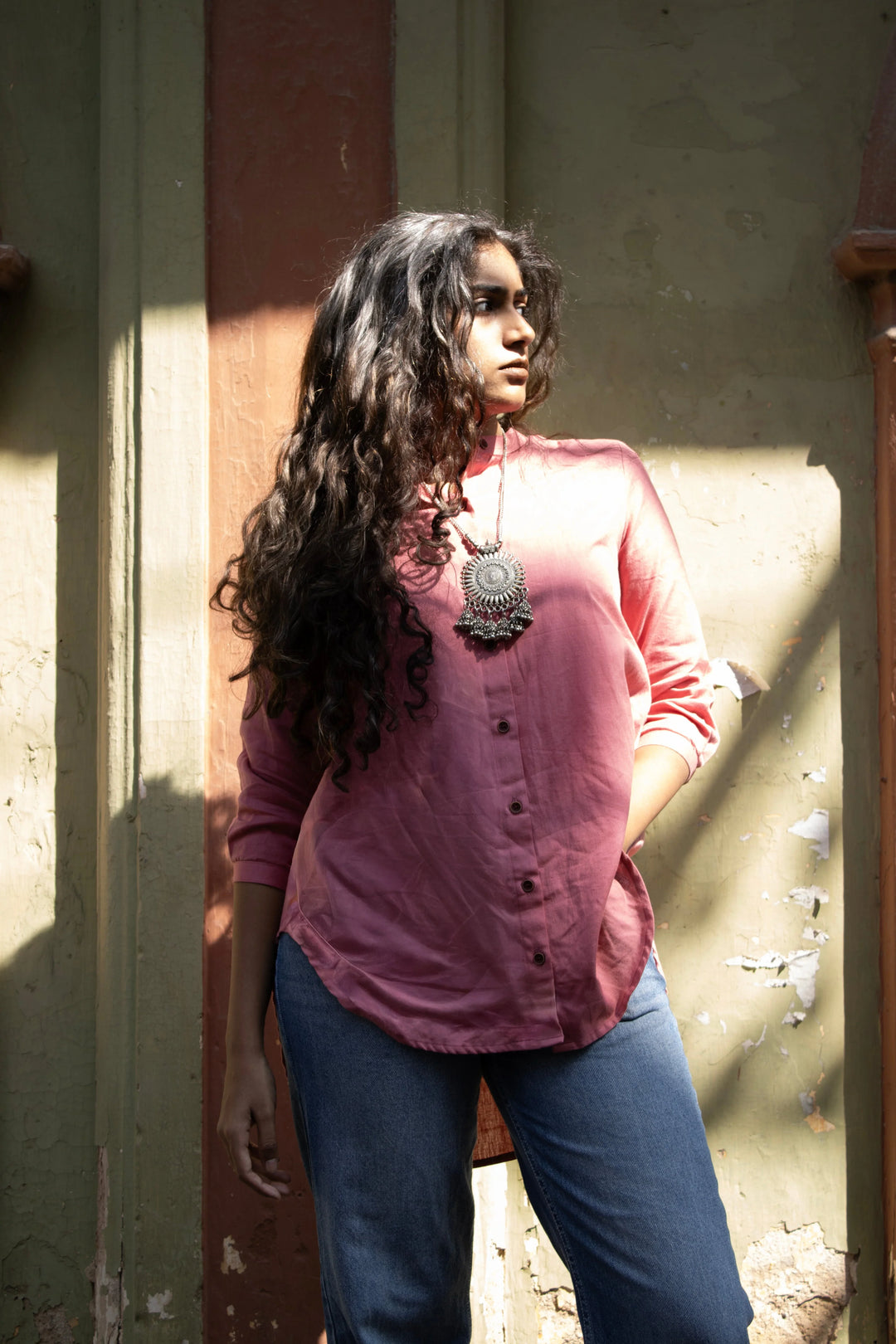 Model wearing a pink tunic shirt paired with a comfort fit enim